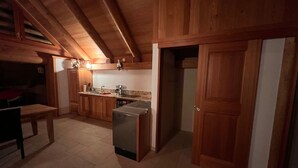 A wooden kitchen with a refrigerator, sink, and cabinets. - Casa Isabella by Interhome (Peccia)