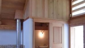 A kitchen with wooden cabinets, a stainless steel sink, and a built-in stove. - Casa Isabella by Interhome (Peccia)