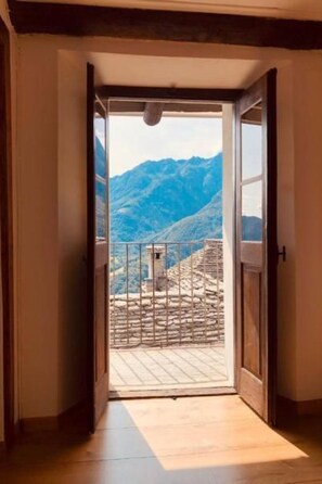 A doorway leading to a balcony with a mountain view. - Casa Ruscada by Interhome (Camedo)