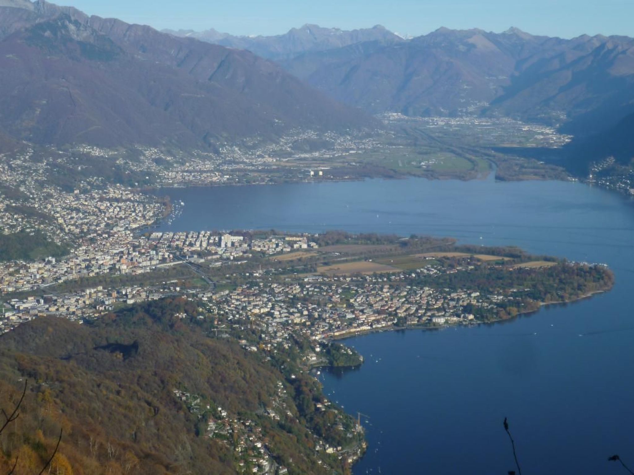 Une ville côtière avec une île centrale, entourée de montagnes.