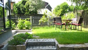 A stone staircase leading to a grassy patio area with outdoor furniture. - Moderne, niveauvoll eingerichtete Ferienwohnung by Interhome (Carlsfeld)