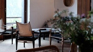 A cozy room with a large window, a woven wall hanging, and a wooden door. - La Stalla by Interhome (Faido)