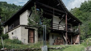 A traditional chalet with a steeply pitched roof, wooden balcony, and a stone foundation. - La Stalla by Interhome (Faido)
