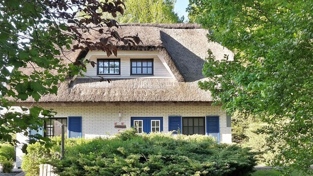 A traditional house with a thatched roof, a brick facade, and blue shutters. - Haus-Zauberblau by Interhome (Groß Schoritz)