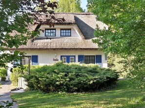 A traditional house with a thatched roof, a brick facade, and blue shutters. - Haus-Zauberblau by Interhome (Groß Schoritz)