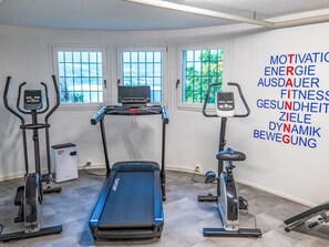 A fitness room with a treadmill, elliptical, and stationary bike, and motivational words on the wall. - Residenza Viramonte - Casa Aurelia, Wohnung 6 by Interhome (Vira)