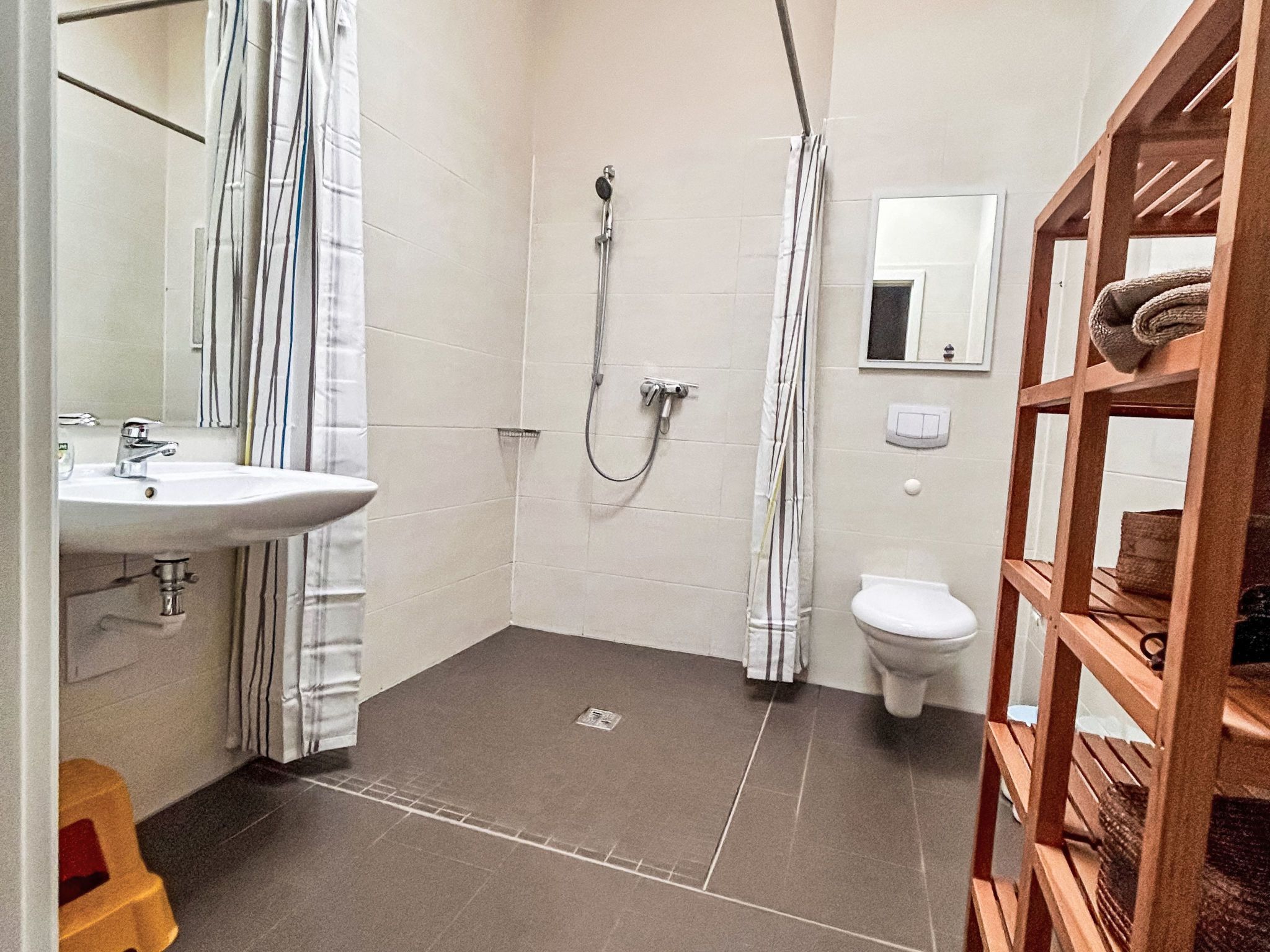 Ein kleines Badezimmer mit Dusche, Toilette und Waschbecken.