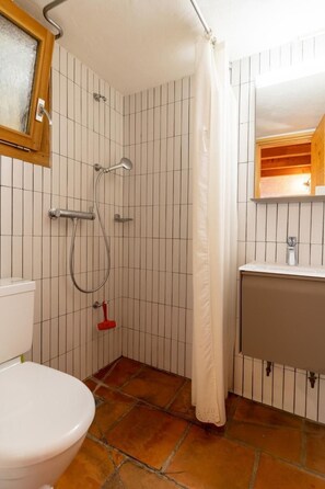 Ein Badezimmer mit Dusche, Toilette und Waschbecken.