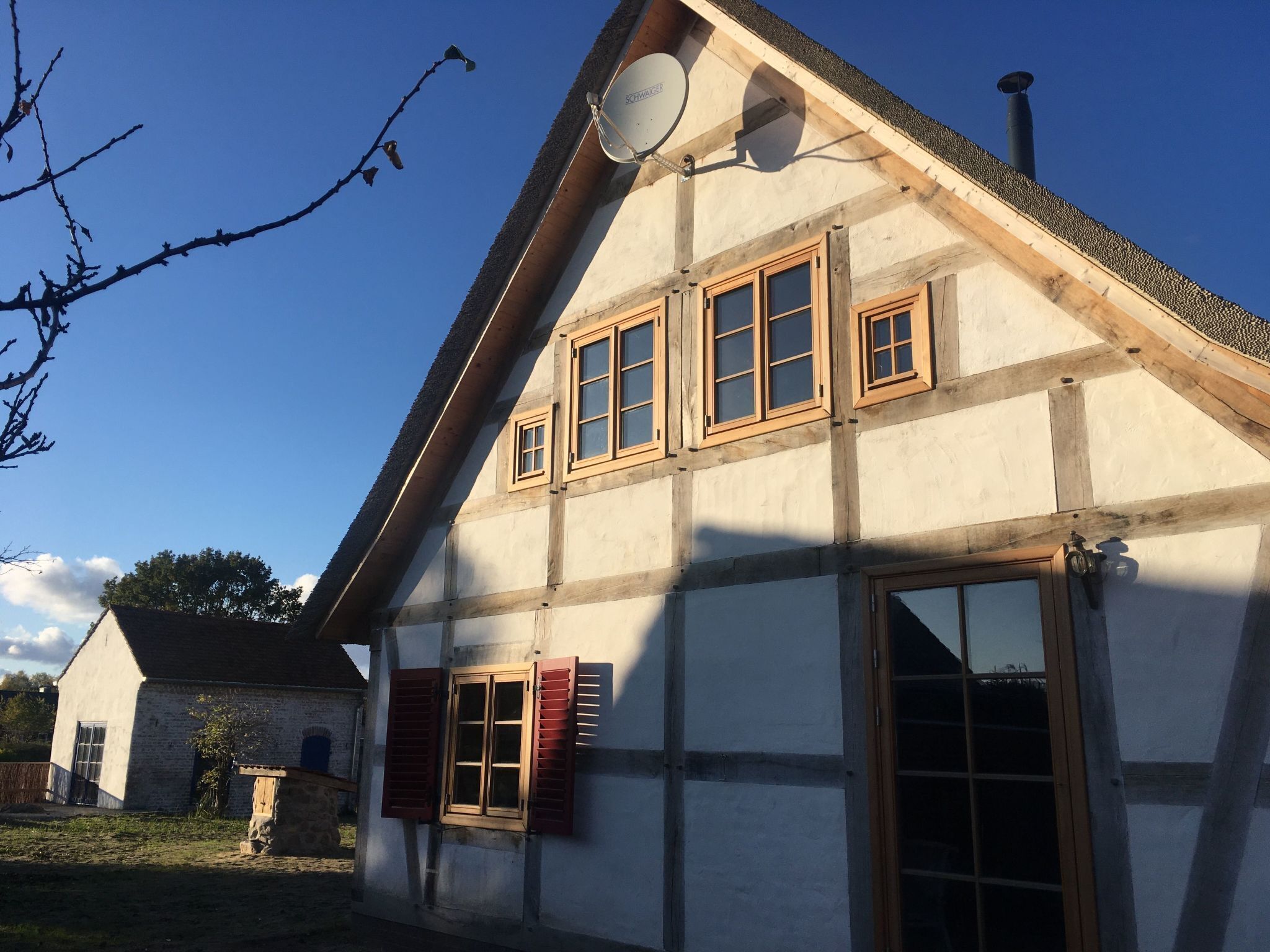 Ett traditionellt hus med korsvirkesfasad, ett sluttande tak, flera fönster och en skorsten.