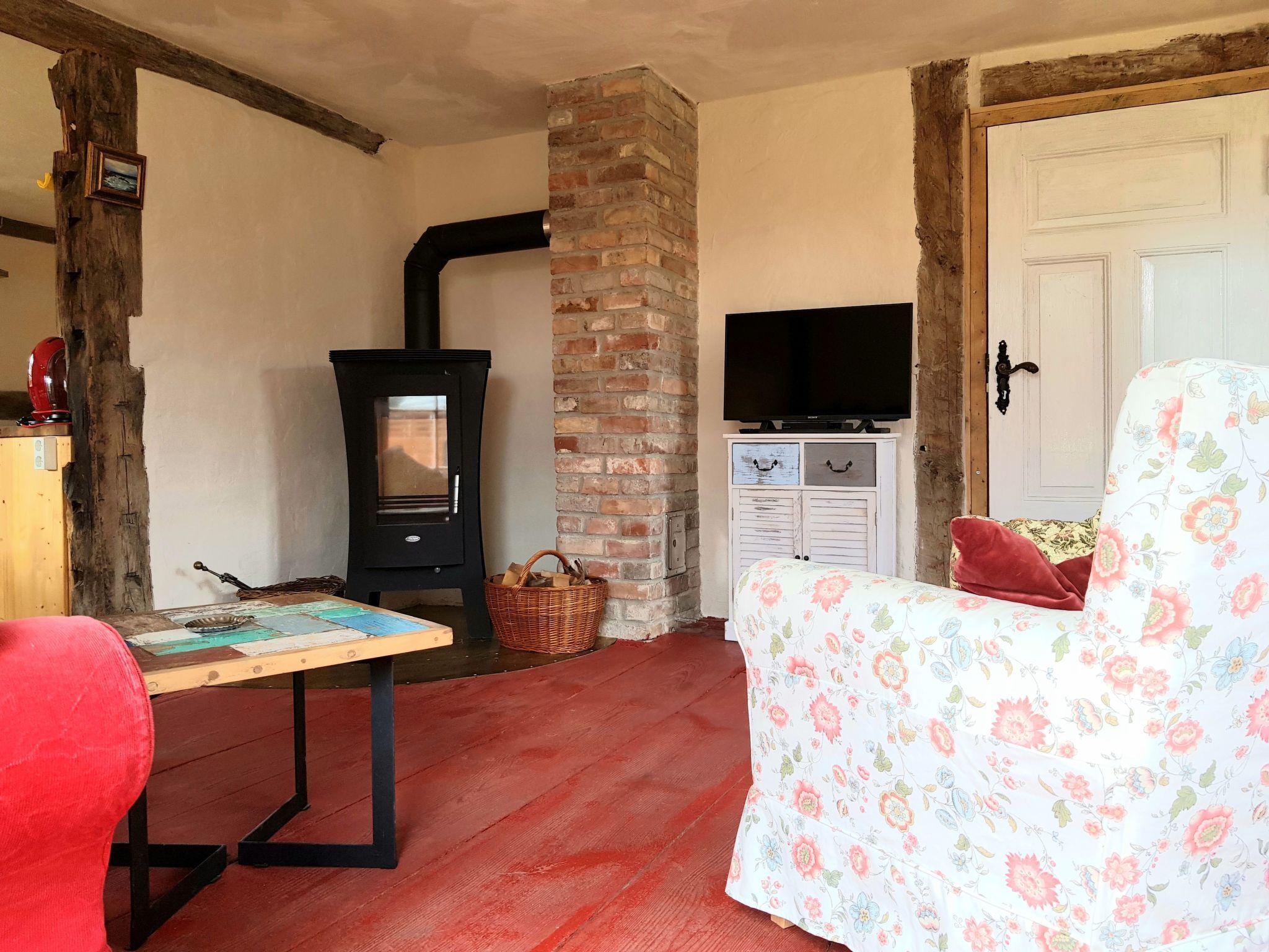 Een gezellige kamer met een open haard, een televisie, een bloemenbank en een tafel met een spel.