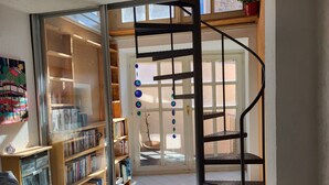 Eine Wendeltreppe führt zu einem Balkon mit Blick ins Freie.