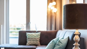 Ein modernes Wohnzimmer mit einer Ledersofa, einem Glastisch und einer Zierleuchte.