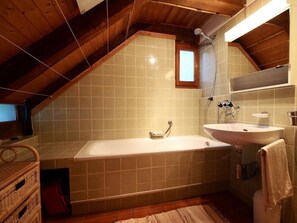 A bathroom with a bathtub, a sink, and a shower. - Casa Studer by Interhome (Aurigeno)