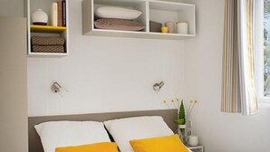 Une chambre à coucher bien rangée, avec un lit, des tables de chevet et des étagères intégrées.