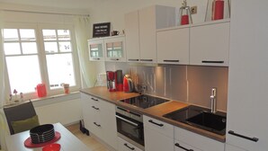 Una cucina moderna con mobili bianchi, un piano cottura nero e una finestra vista panoramica.