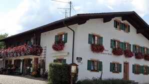 A traditional building with multiple windows, some with flower boxes. There is a sign with the name "Haus Schuster Best" and a number "62" on the building. - Apartment Bärli by Interhome (Bad Bayersoien)
