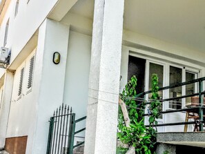A building facade with a white exterior, a metal gate, and a window with a view of a balcony. - "SeaSide" mit Blick auf das Wasser by Interhome (Klek)