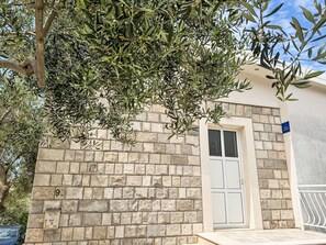 A stone building with a white door and a mailbox labeled '90'. - Angenehme Wohnung in Komarna mit privatem Parkplatz by Interhome (Klek)