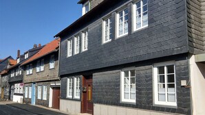 Une rangée de bâtiments européens traditionnels, avec des façades en bois foncé et des encadrements de fenêtres blancs.