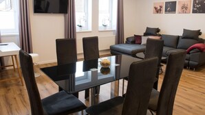 A modern living room with a dining table, sofa, and TV. - in Goslar mit Terrasse und Grill by Interhome (Goslar)