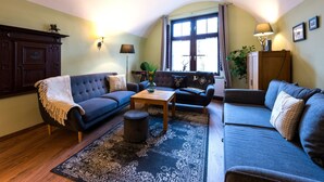 Ett mysigt vardagsrum med en mörkblå soffa, ett träbord och en mönstrad matta.