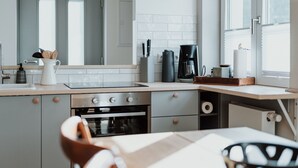 Una cocina moderna con horno integrado, cafetera y un reloj en la pared.