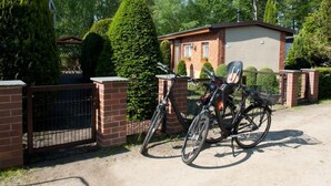 A gated residential area with a single-story brick house, a bicycle, and a well-maintained lawn. - in Alt-Schadow mit Grill und Terrasse by Interhome (Jessern)