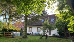 Una casa con tetto in tegole, veranda coperta e prato.