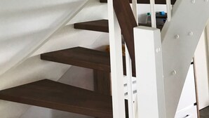 Un escalier avec des marches en bois et des rampes blanches.