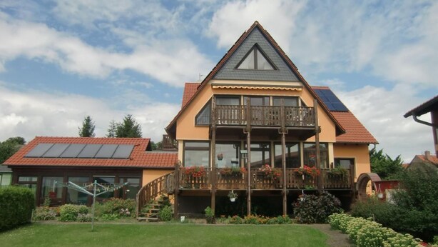 A two-story house with a balcony, solar panels, and a well-maintained garden. - Nette Wohnung mit Garten, Grill und Pool by Interhome (Beetzsee)