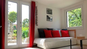 Une chambre à coucher avec un lit, une petite table et une fenêtre.
