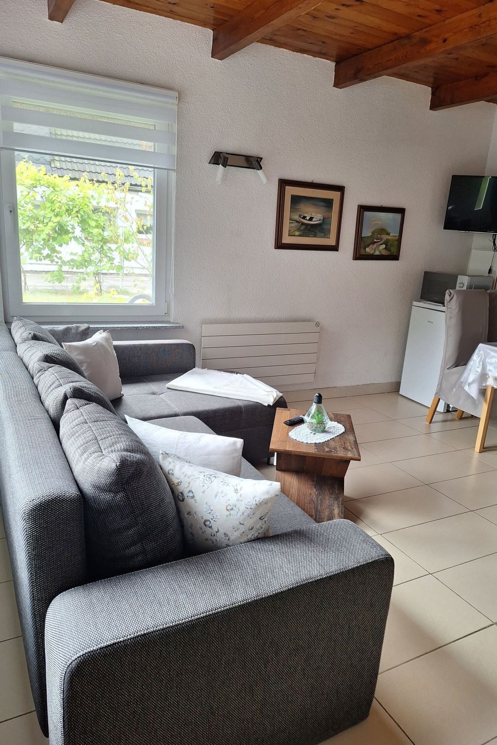 A living room with a sofa, a small coffee table, and a television.