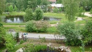 A lakeside view with a wooden fence, a small dock, and houses in the background. - in Bayerisch Eisenstein mit Garten by Interhome (Bayerisch Eisenstein)