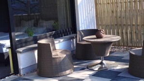 An outdoor patio area with wicker furniture and a stone-tiled floor. - Eifelhaus4you by Interhome (Schleiden)