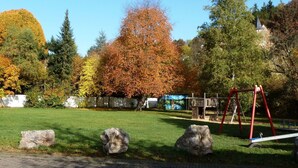 A park with a swing set, large rocks, and autumn-colored trees. - Eifelhaus4you by Interhome (Schleiden)