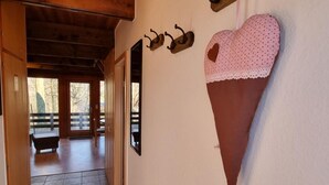 A hallway with wooden ceiling, a heart-shaped decoration, and wall-mounted hooks. - Marie 125 by Interhome (Bad Arolsen)