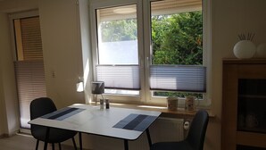 A dining area with a table and chairs, a window with blinds, a lamp, and a radiator. - Urlaub und zu Hause by Interhome (Naundorf)