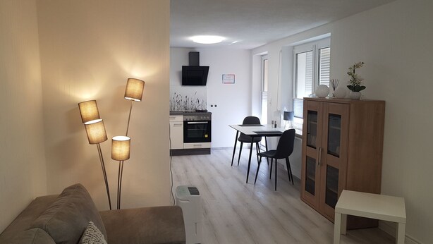 A modern living room with a sofa, a standing floor lamp, and a dining area with a table and chairs. - Urlaub und zu Hause by Interhome (Naundorf)