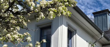 Ein zweistöckiges Gebäude mit weißen Außenwänden und blauen Fensterrahmen.