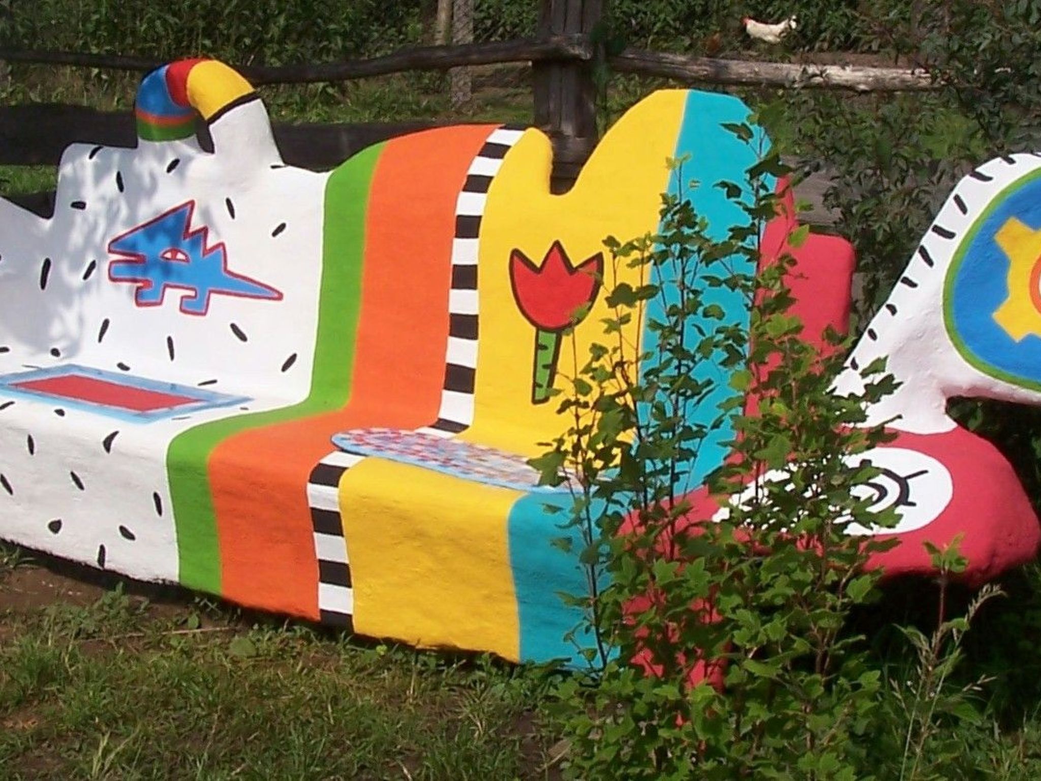 A colorful, whimsical boat-shaped structure with various painted symbols and patterns.