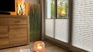 A room with a wooden cabinet, a lit candle, and a window with blinds. - in Strandnähe by Interhome (Bad Doberan)