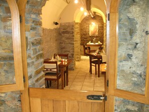 An interior dining area with stone walls and wooden furniture. - Schneemann by Interhome (Cochem)