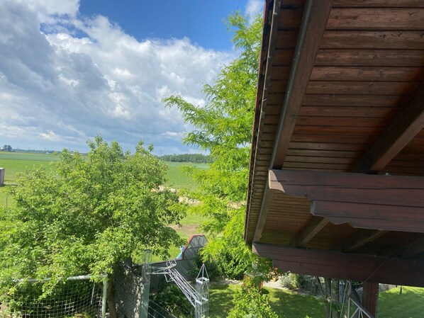 Una estructura de madera con vistas a un paisaje verde y árboles.