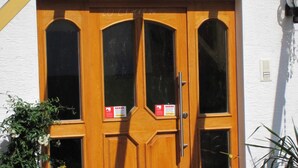 Puerta de madera con dos paneles de vidrio y un tirador de metal.