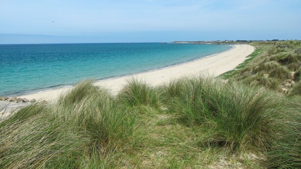 A beach with a sandy shore and grassy dunes. - Ty Coz Castel by Interhome (Goulven)