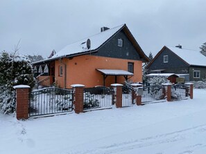 A two-story house with a brick foundation and a snow-covered roof. - Waldperle by Interhome (Altwarp)