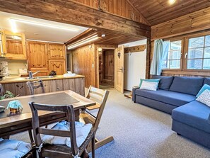 A wooden interior with a dining area, kitchen, and living room. - Scheftenau by Interhome (Wattwil)