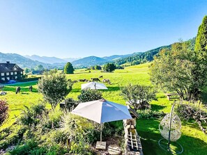 A rural landscape with a house, a grassy field, and a mountain range in the background. - Scheftenau by Interhome (Wattwil)