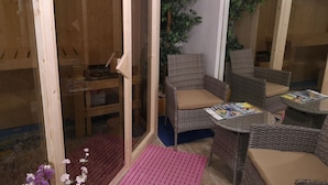 A cozy room with wicker furniture, a glass door, and a wooden interior. - City FH Vulkaneinfel by Interhome (Daun)
