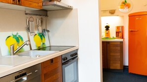 Eine Küche mit Holzausstattung, einem Siemens Geschirrspüler, einem Backofen und einer Kaffeemaschine.